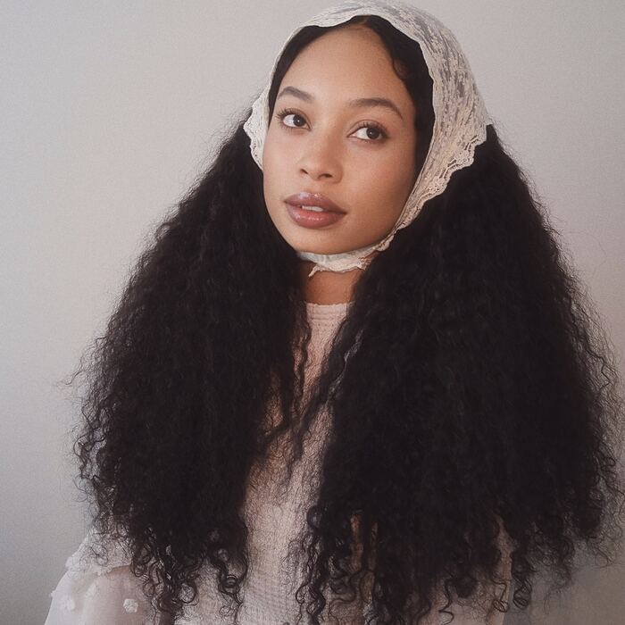 Orie in a lace headscarf with long curls